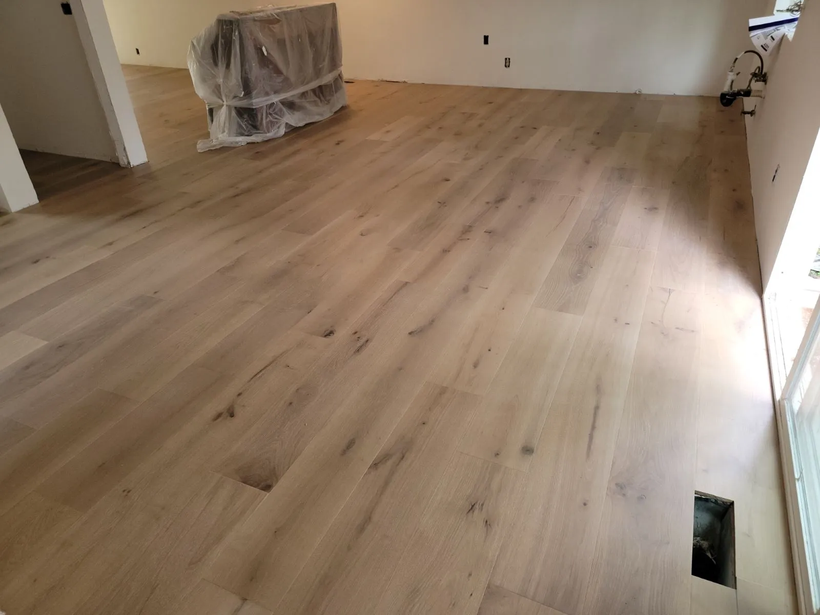 New wide-plank hardwood floor in an empty room