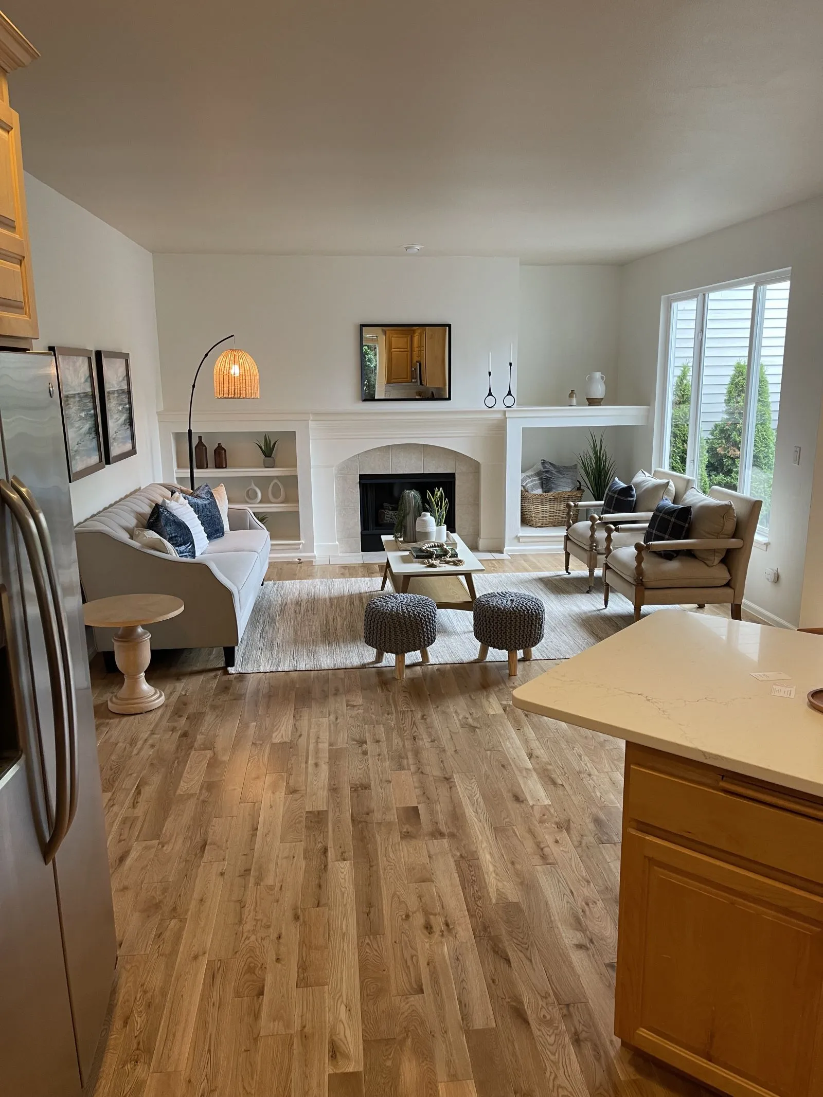 New wide-plank hardwood floor in a living room with a fireplace