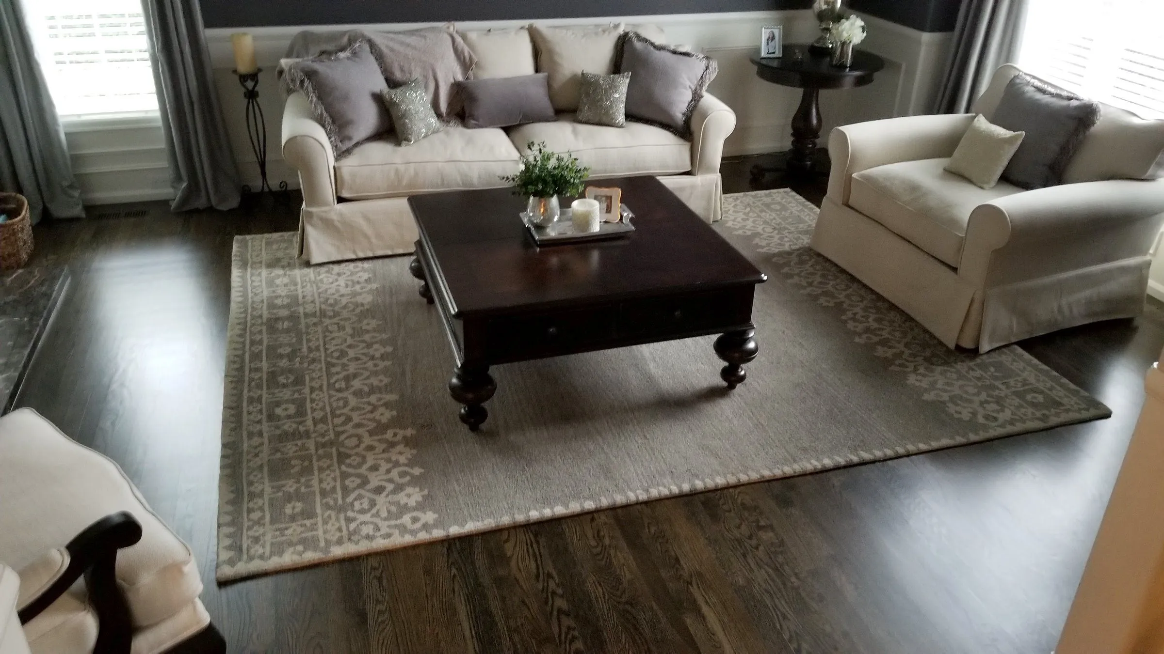 Dark stained hardwood floor in a living room with white sofas