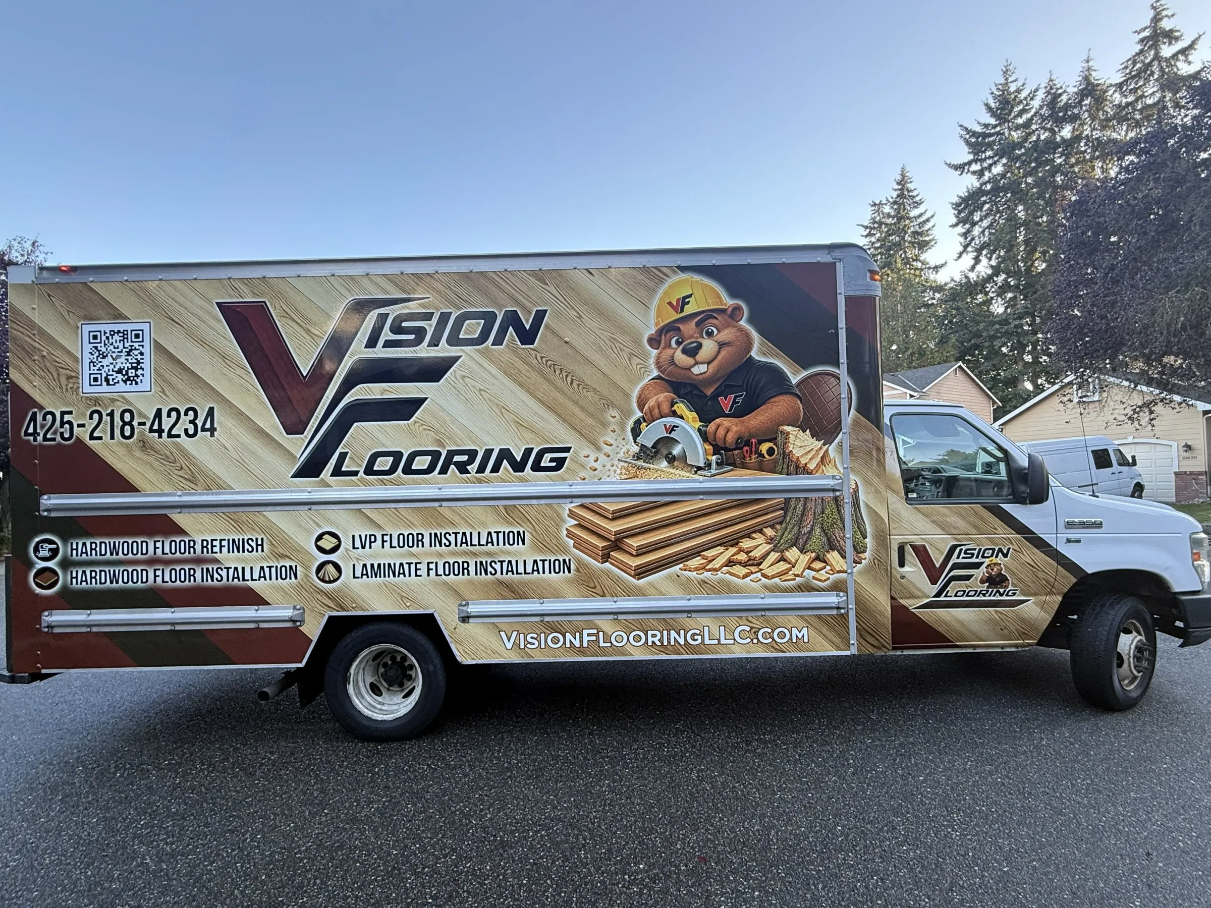 Vision Flooring box truck with the beaver mascot wrap, parked on a residential street